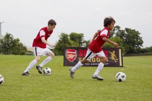 Jugar al fútbol con la escuela oficial del Arsenal, con la equipación correspondiente
